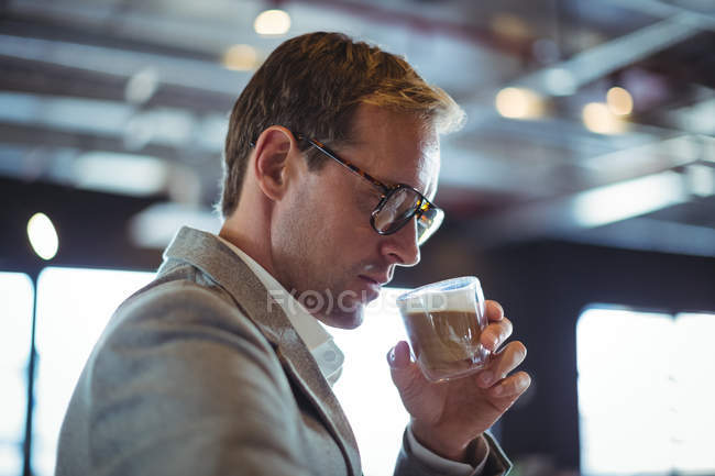 Homme d'affaires confiant prenant un café au café — Photo de stock