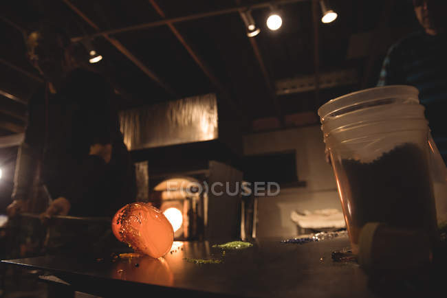 Скляні пилососи прокату розплавленого скла на шматочках кольорового скла на скляній фабриці — стокове фото