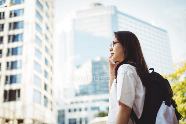 Young woman talking on mobile phone on street — Stock Photo