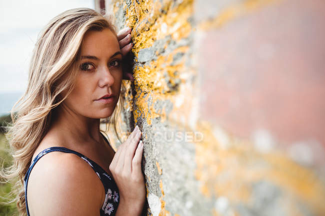 Retrato de mulher apoiada na parede no penhasco — Fotografia de Stock