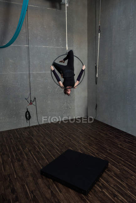 Young woman performing gymnastics on hoop in fitness studio — Stock Photo