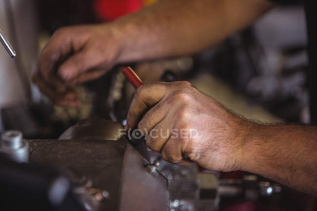 Mécanicien travaillant sur une machine de tour industrielle en atelier — Photo de stock