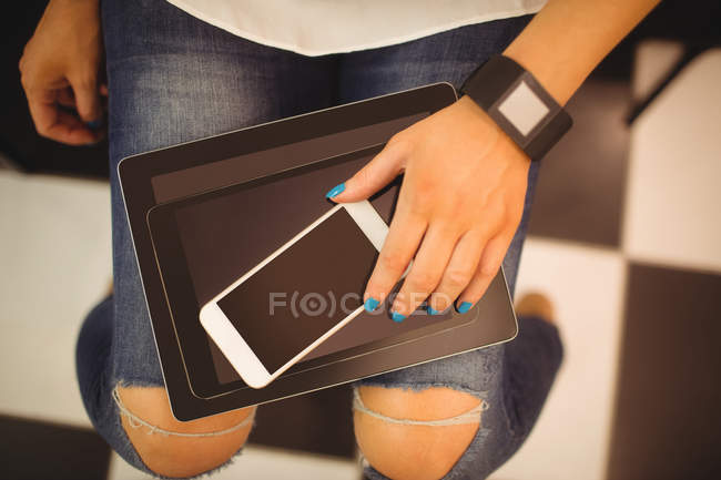 Hand of woman holding mobile and digital tablets at hair saloon — Stock Photo