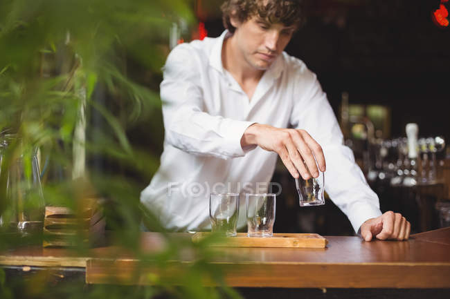 Barista organizzare bicchiere di birra sul vassoio al bancone del bar nel bar — Foto stock
