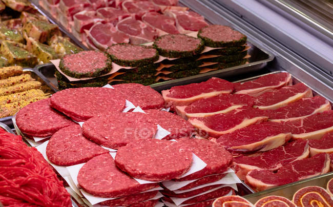 Varietà di carne marinata al banco espositore in macelleria — Foto stock