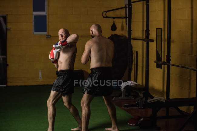 Boxers tailandeses praticando boxe no ginásio escuro — Fotografia de Stock