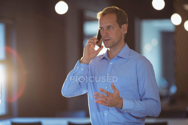Бізнесмен розмовляє по мобільному в офісі. — стокове фото