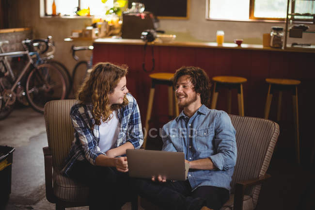 Couple using laptop in workshop — Stock Photo