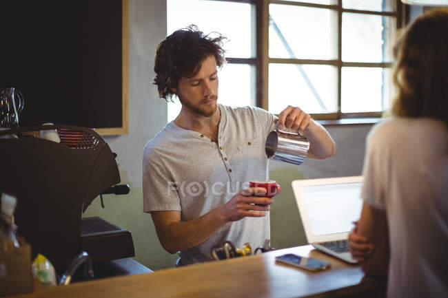 Mechanic preparing coffee at counter in workshop — Stock Photo
