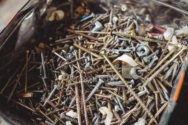 Close-up of screws, nuts and nails in a container at boatyard — Stock Photo