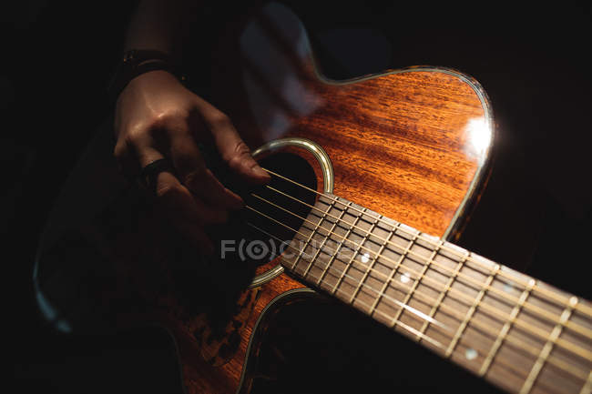 Mid-section of woman playing a guitar in music school — Stock Photo