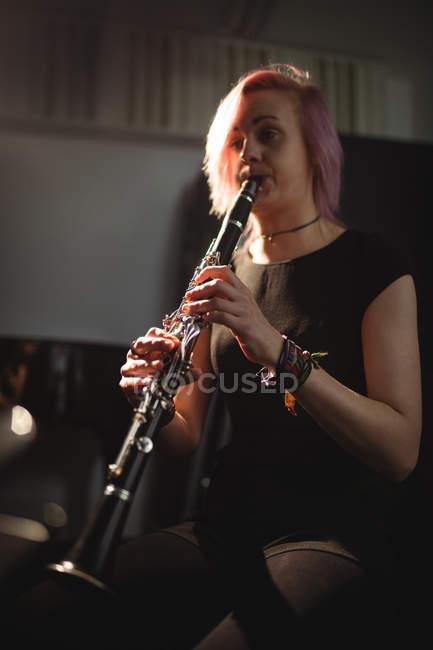 Красивая женщина играет на кларнете в музыкальной школе — стоковое фото