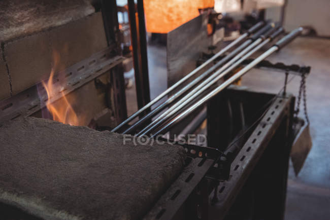 Primer plano de la pieza de vidrio calentada en el horno en la fábrica de soplado de vidrio - foto de stock