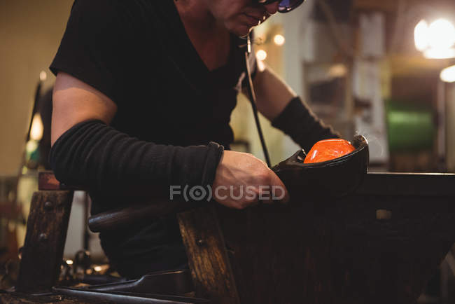 Glassblower forming and shaping molten glass at glassblowing factory — Stock Photo