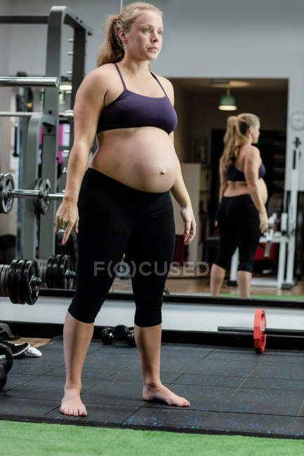 Bella donna incinta che esercita in palestra — Foto stock
