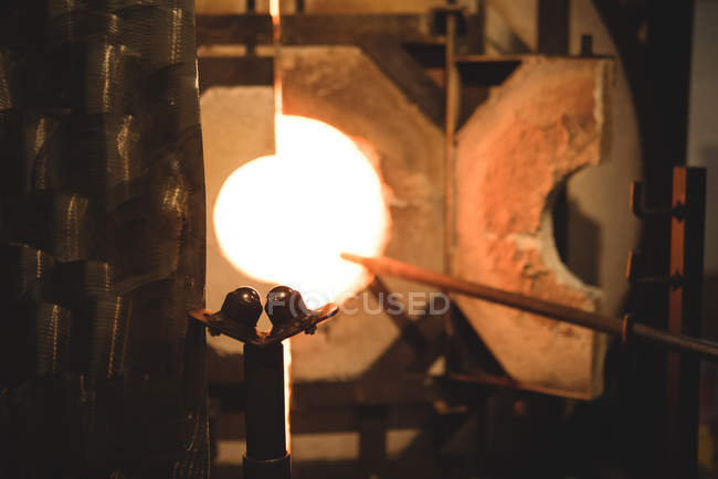 Primo piano di un pezzo di vetro riscaldato in forno nella fabbrica di soffiaggio del vetro — Foto stock