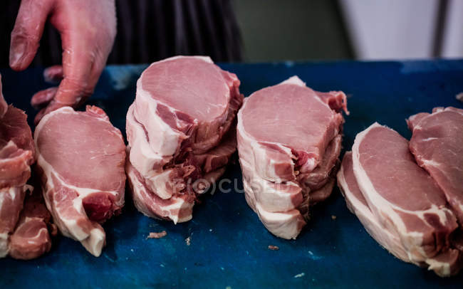 Сырые стейки хранятся на рабочем столе в мясной лавке — стоковое фото