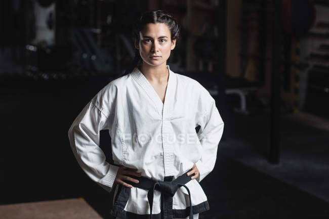 Porträt einer Karate-Frau, die mit den Händen auf den Hüften im Fitnessstudio steht — Stockfoto