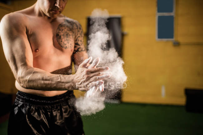 Abgeschnittenes Bild eines Boxers, der im Fitnessstudio Talkumpuder auf die Hände aufträgt — Stockfoto