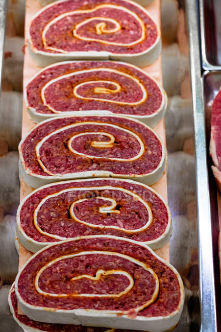 Rollos de carne picada en exhibición en la carnicería, primer plano - foto de stock