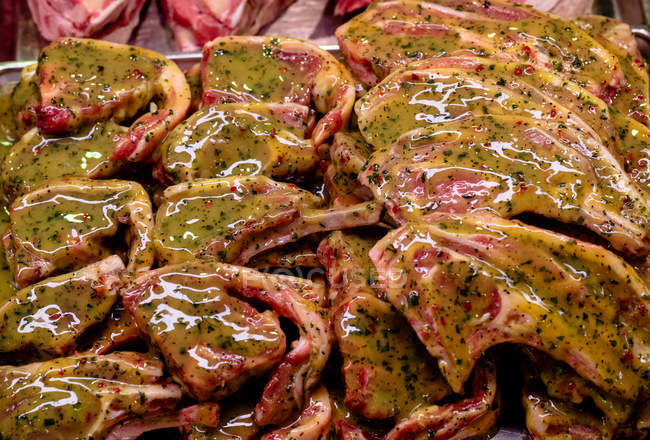 Marinaded meat at display counter in butchers shop — Stock Photo