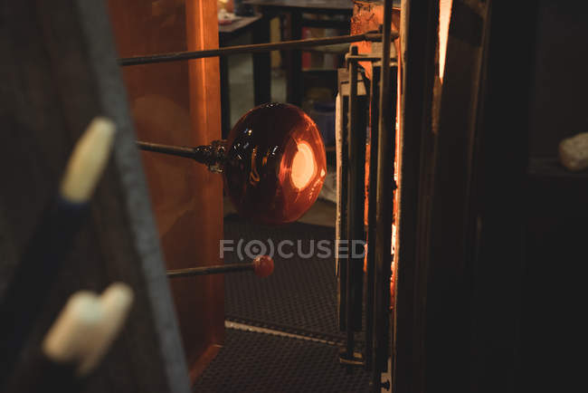 Close-up of molten glass on blowpipe at glassblowing factory — Stock Photo