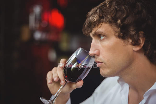 Homme prenant un verre de vin rouge au bar — Photo de stock