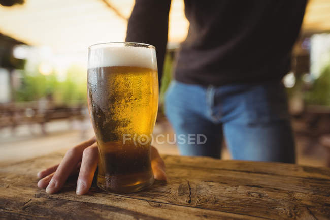 Mezzo sezione di uomo con bicchiere di birra al bar — Foto stock