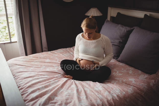 Вагітна жінка розслабляється в спальні вдома — стокове фото