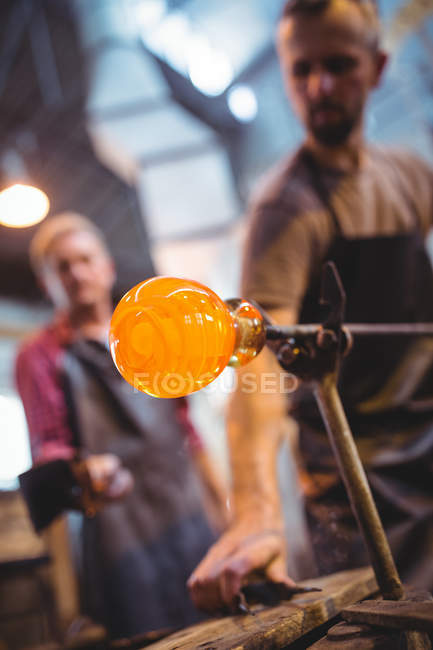 Glassblowers shaping a molten glass at glassblowing factory — Stock Photo