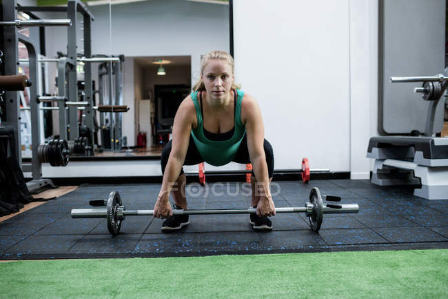 Беременная женщина, тренирующаяся со штангой в спортзале — стоковое фото