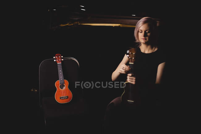 Красива жінка грає на гітарі в музичній школі — стокове фото