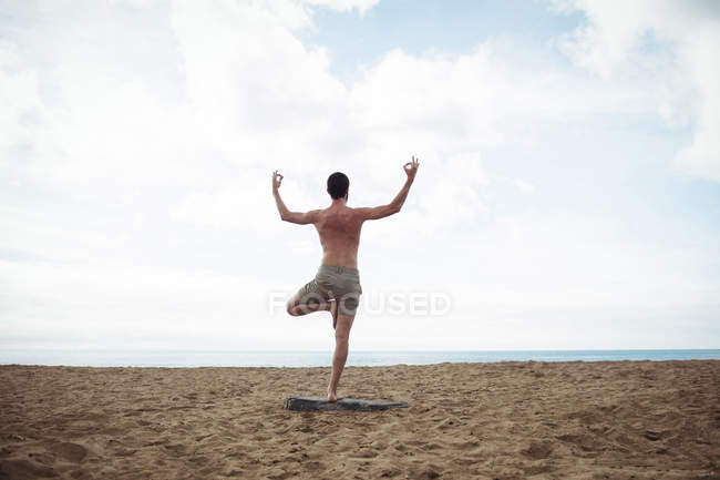 Чоловік виконує йогу на пляжі — стокове фото