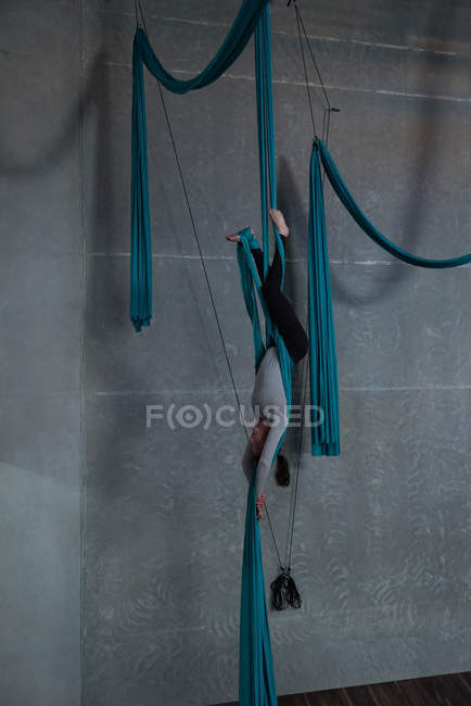 Гімнаст вправи на синій тканинній мотузці в фітнес-студії — стокове фото