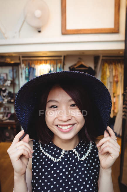 Beautiful woman wearing hat in boutique store — Stock Photo