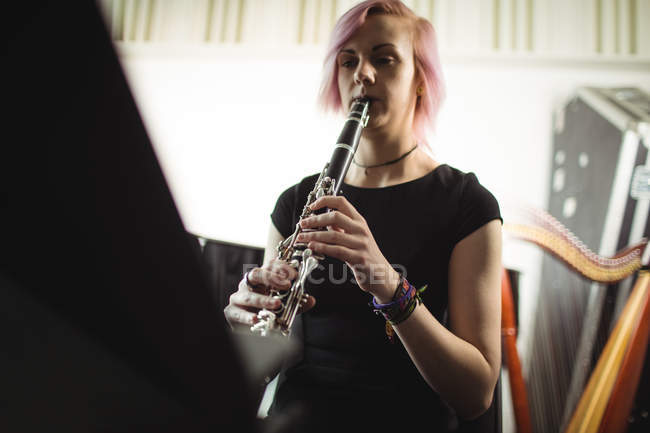 Schöne Frau spielt Klarinette in der Musikschule — Stockfoto