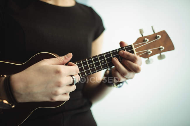Середній розділ жінки, що грає на гітарі в музичній школі — стокове фото