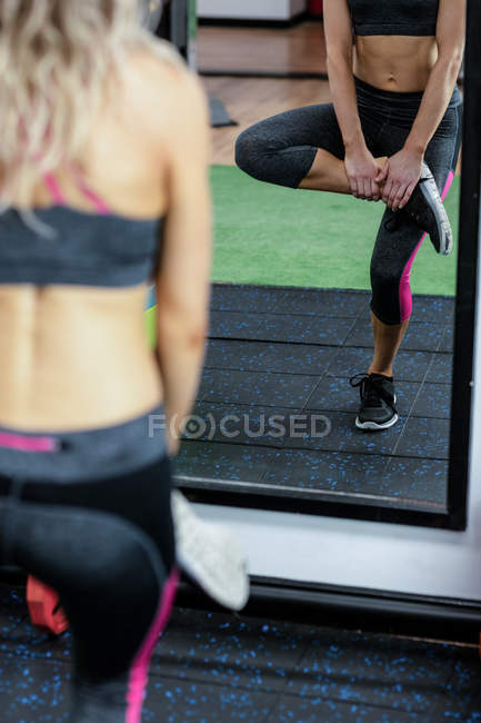Woman performing exercise in gym — Stock Photo