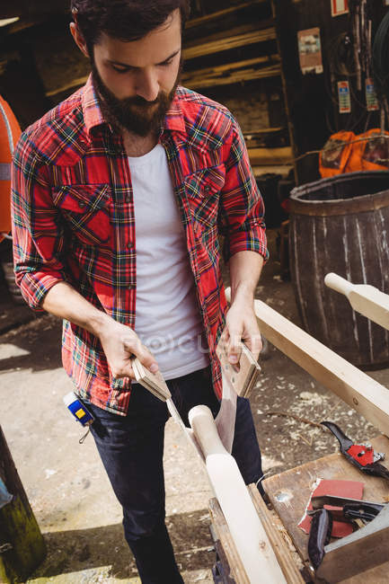 Homme travaillant sur planche de bois dans le chantier naval — Photo de stock