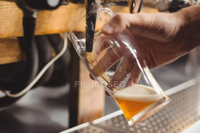 Primer plano de la barra de llenado de cerveza de la barra de la bomba en el mostrador de bar - foto de stock