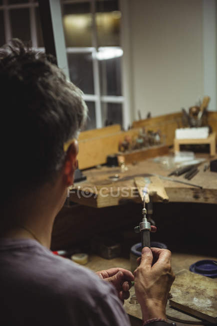 Handwerker hält Fackel in Werkstatt — Stockfoto