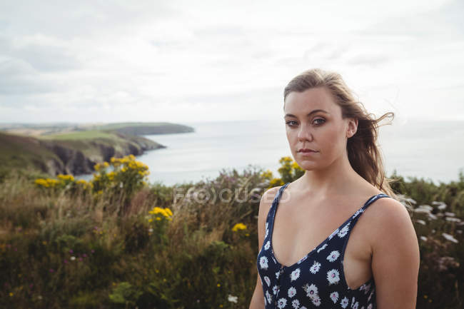Retrato de mulher em pé no penhasco sobre o mar — Fotografia de Stock