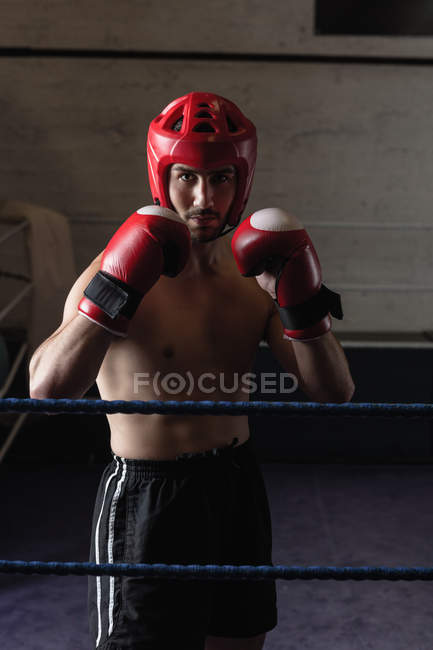 Boxeador sin camisa practicando boxeo en gimnasio - foto de stock