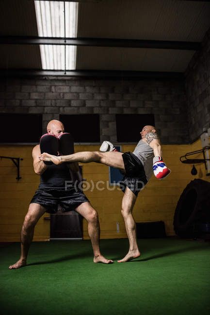 Низький кут зору двох тайських боксерів, які практикують в спортзалі — стокове фото
