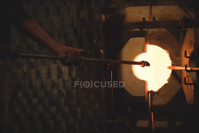 Стеклодувка нагревательного стекла в печи на стекольном заводе — стоковое фото