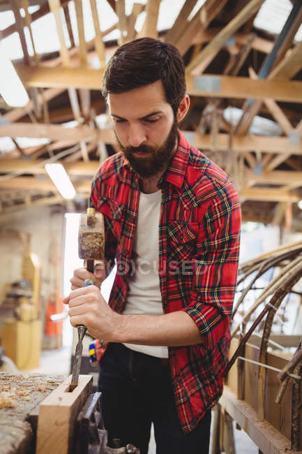 Человек, работающий над деревянной доской на верфи — стоковое фото