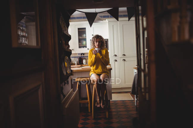 Hermosa mujer tomando café en la cocina en casa - foto de stock