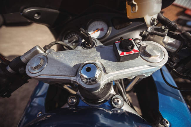 Close-up of motorcycle handlebar with key at workshop — Stock Photo