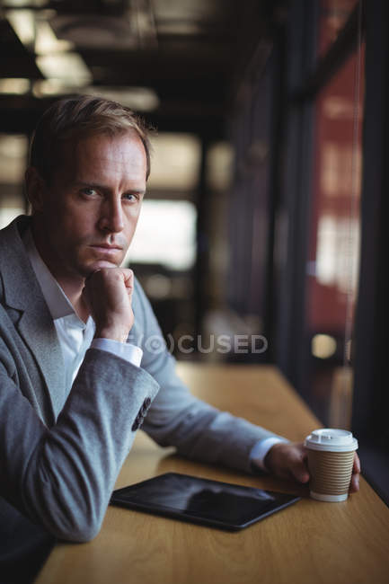 Retrato de homem de negócios sentado no café com um tablet digital e café — Fotografia de Stock