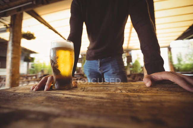 Средняя секция человека со стаканом пива в баре — стоковое фото